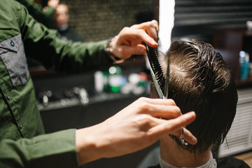 Fototapeta na wymiar Men's hairstyling, haircutting, in a barber shop or hair salon.