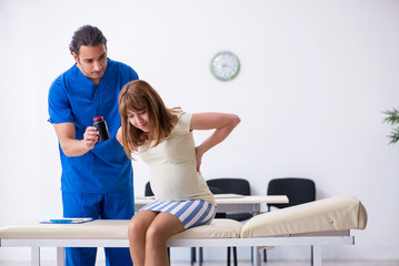 Obraz premium Pregnant woman visiting male doctor gynecologist