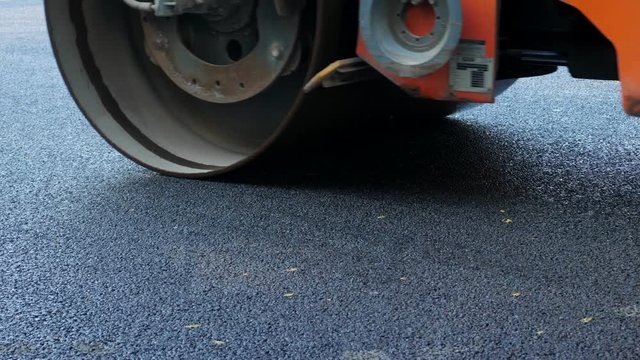 industrial pavement truck laying fresh asphalt on construction site. Roller rolling fresh hot bitumen on new road. Road construction