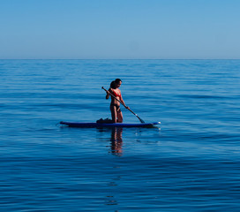 Fototapeta na wymiar Close-up Asian woman kneeling on standup paddle board Sea of Cortez.