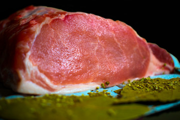 raw pork loin on a dark background and Bay leaves