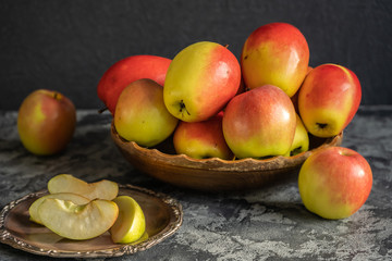 Fresh apples on a wooden plate, sliced apples on a metal plate