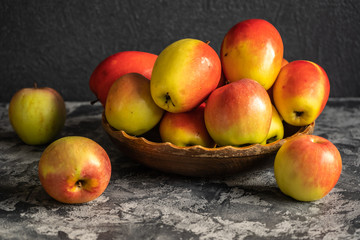 Fresh apples on a wooden plate