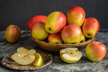 Naklejka na ściany i meble Fresh apples on a wooden plate, sliced apples on a metal plate