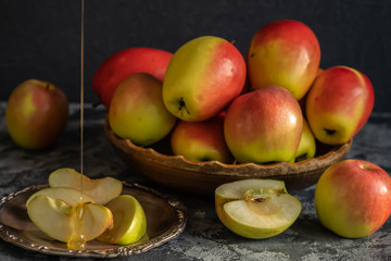 Fresh apples on a wooden plate, sliced apples on a metal plate with honey