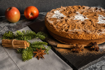 Apple pie with cinnamon on the table, Christmas fir branch on the table with cinnamon sticks and star anise