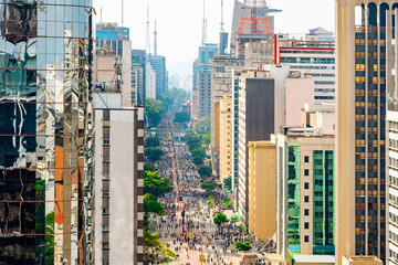 Aerial view of Paulista avenue full of people walking on the street and the tall buildings of the...