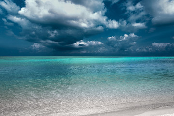 Fototapeta na wymiar tropical island beach view with dark blue sky