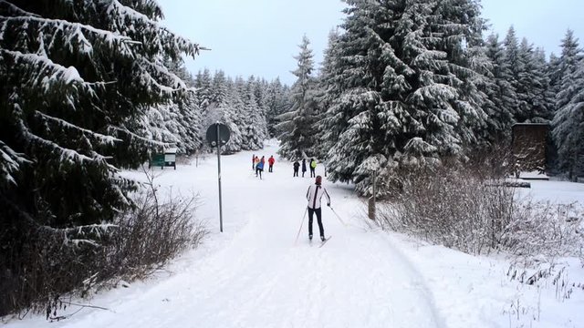 Rennsteig hiking path in Oberhof, Germany, winter season, skiing people and tourists