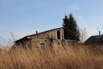 old ruined house in the village in a dirty fence uninhabited abandoned building