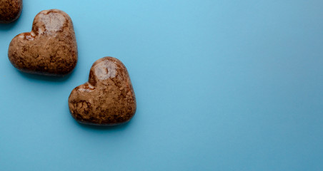 Valentine's flat lay with love chocolate gingerbread heart  on colorful blue background, greeting card copy space top view. The celebration of Valentine's Day.