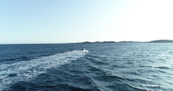 Drone footage of white motor boat hading open water sea. (Norway, Helleviga)