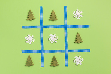 New Year tic tac toe game, isolated on green background. Christmas, winter concept. Flat lay, top...