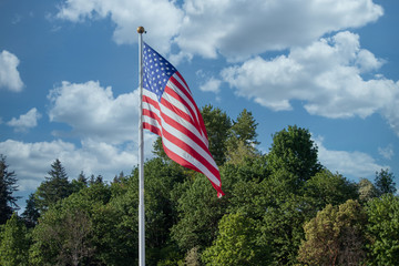 weather with cloudy sky behind american flag blowing in the wind