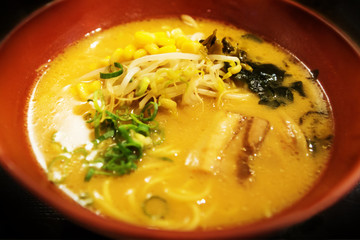 Yellow miso soup with vegatables and chicken in clay bowl, Japan