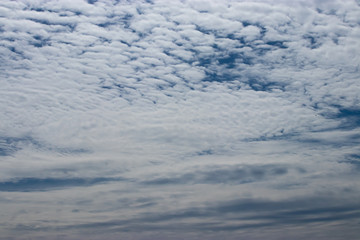 white whispy clouds covering a blue sky