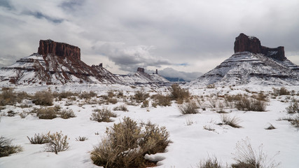 Snow covered desert landscape in Castle Valley Utah viewing Castleton Tower and Parriott Mesa near Moab in winter.