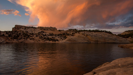 Colorful sunset reflecting in desert lake at Red Fleet Reservoir in Utah.