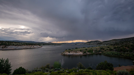 Storm blowing over lake with dark clouds through the sky.