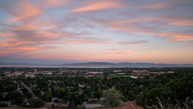 Overlooking Provo during colorful sunrise looking past Brigham Young University towards Utah Lake in the morning.