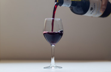 wine being poured into the glass bowl with the movement of the wine as it touches the edges of the glass.