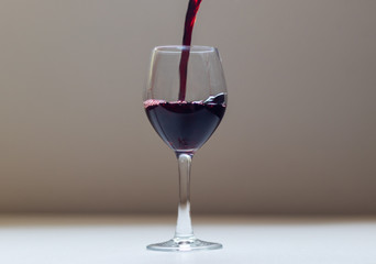 wine being poured into the glass bowl with the movement of the wine as it touches the edges of the glass.