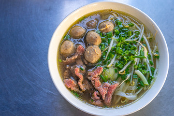 Bowl of tasty Vietnamese beef noodle soup on table