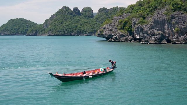 Group of Islands in ocean at Ang Thong National Marine Park near touristic Samui paradise tropical resort. Archipelago in the Gulf of Thailand. Idyllic turquoise sea natural background with boat.