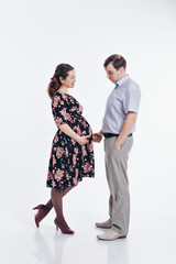 loving couple embracing on a white background. A man and a woman look into each other's eyes. Husband hugs pregnant wife. Valentine's day. February 14