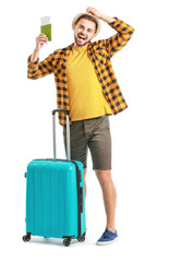 Young male tourist with luggage on white background