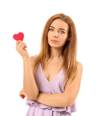 Beautiful young woman with small red heart on white background