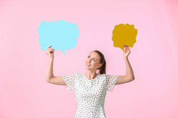 Young woman with blank speech bubbles on color background
