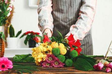 Female florist making beautiful bouquet at table