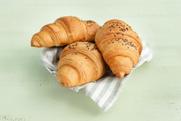 Plate with tasty croissants on white table