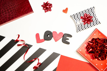 Valentine's day romantic party concept. Gift boxes, heart shape, sweets, black and red decorations on white background. Top view, flat lay, copy space