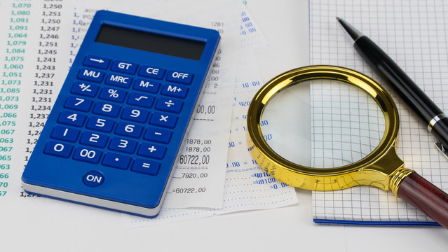 Calculator and magnifier on top of supermarket receipt. Shopping and payment concept