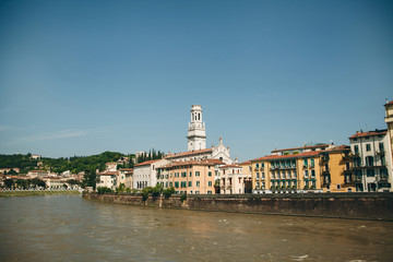 View of traditional old houses and a cathedral or church and river in Verona in Italy.