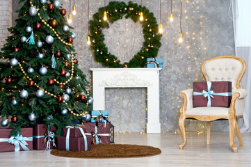 Christmas tree with blue and brown gifts in the white room Christmas. Beautifully decorated house with a silver, brown and blue tree and presents at Christmas.