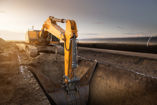 Crane digging a channel for gas pipeline