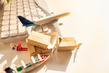 Miniature people: Worker and brown paper box, white keyboard on blurred city with airplane, ship using as background business shipping, rent container, worldwide transportation concept.