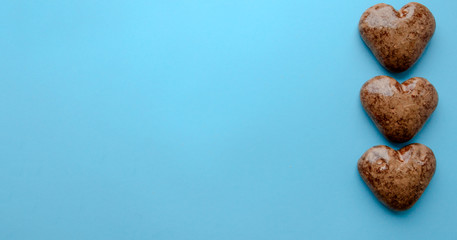 Valentine's flat lay with love chocolate gingerbread heart on colorful blue background, greeting card copy space top view. The celebration of Valentine's Day.