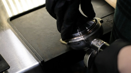 Barista at work. The process of making coffee and cacao. A glass of foaming milk. Electric Grinder Grinds Coffee Beans In Filter Holder.