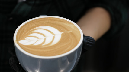Barista at work. The process of making coffee and cacao. A glass of foaming milk. Electric Grinder Grinds Coffee Beans In Filter Holder.