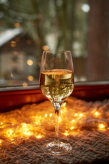 One glass of champagne, sparkling wine. Against the background of the side and garlands. Celebrating the new year. Loneliness.