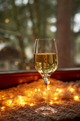 One glass of champagne, sparkling wine. Against the background of the side and garlands. Celebrating the new year. Loneliness.