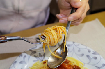 トマトソースをかけたスパゲティーを食べているシーン
