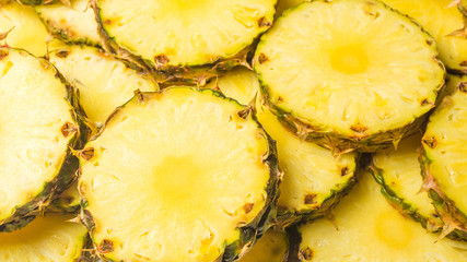 Pineapple juicy yellow slices background. Top view.