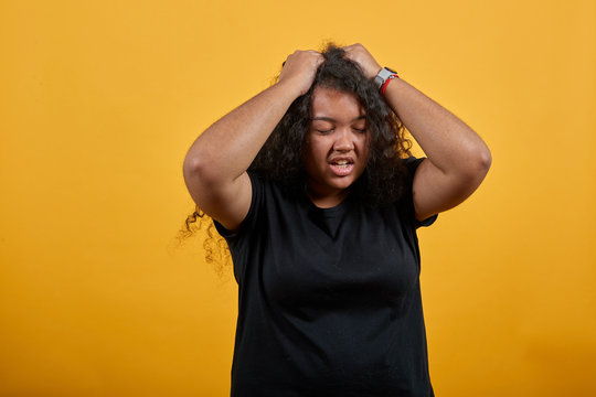 Disappointed Afro-american With Overweight Woman Keeping Hand On Had, Headache Over Isolated Orange Background Wearing Fashion Black Shirt. People Lifestyle Concepte.