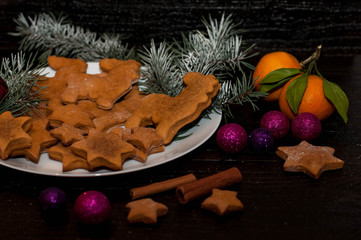 Christmas dark background with festive decoration, cookies, gingerbread and spruce branches