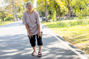 Asian senior woman is extremely tired while walking at park, body is weak feeling tired easily due...